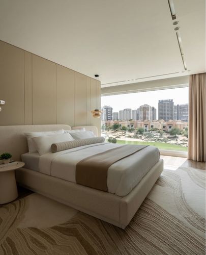 Beige upholstered bed with bolster pillow facing floor-to-ceiling window overlooking Dubai skyline