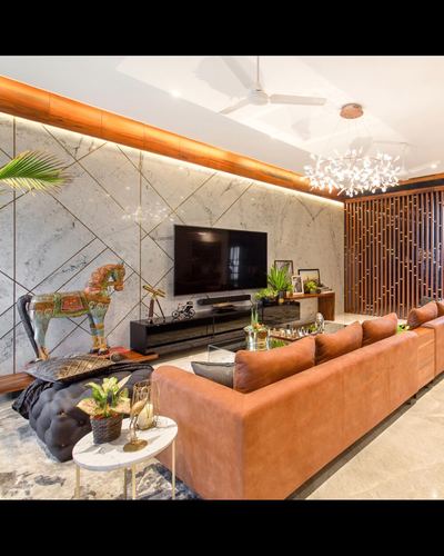 Living room with marble diagonal-patterned wall, orange leather sofa, and slatted wood partition