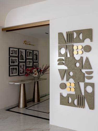 Foyer with marble console, brass legs, gallery wall, and geometric wall art panel