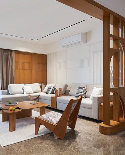 Living room with white sectional sofa, fluted wood panelling, and a carved wooden partition screen