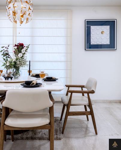 Dining table with marble top, wooden chairs, floral centerpiece, and sculptural pendant light