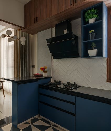 Navy blue modular kitchen with wood-veneer overhead cabinets and herringbone tile backsplash