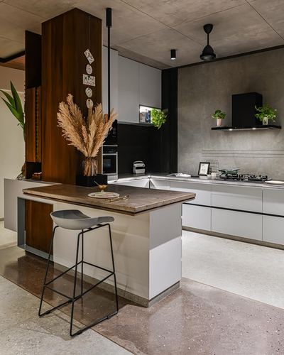 Modern kitchen with wood-clad column, stone island counter, and grey concrete walls