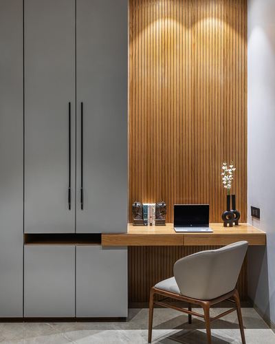 Built-in study nook with fluted wood wall, floating desk, grey wardrobe and cane-legged chair