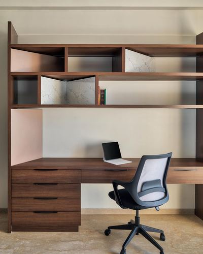 Built-in wooden study unit with open shelving, desk, laptop and mesh office chair