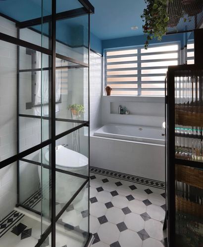 Bathroom with black-framed glass partition, patterned tile floor, built-in tub and blue ceiling