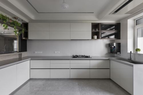 U-shaped modern kitchen with white cabinetry, grey stone counters, and open dark shelving