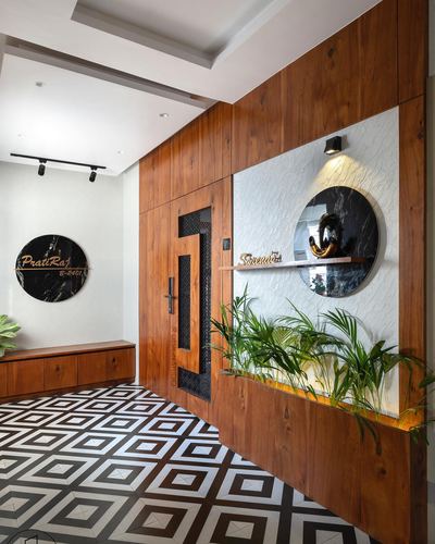 Entrance foyer with wood paneling, round marble nameplate, textured niche and geometric black-white floor