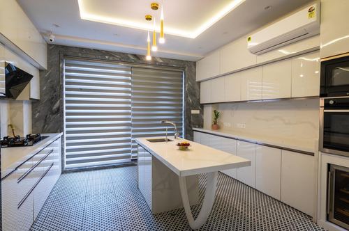 White gloss modern kitchen with marbled accent wall, island, and patterned tile floor