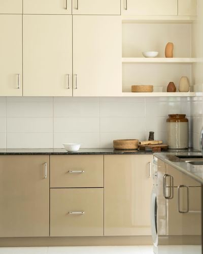 Cream kitchen cabinets with open shelving, dark countertop and beige base units