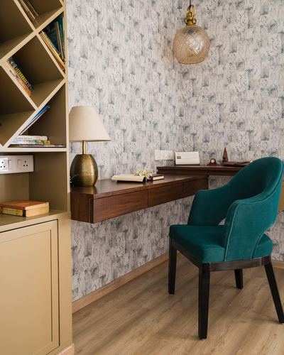 Study nook with floating wood desk, teal velvet chair, and textured stone-pattern wallpaper
