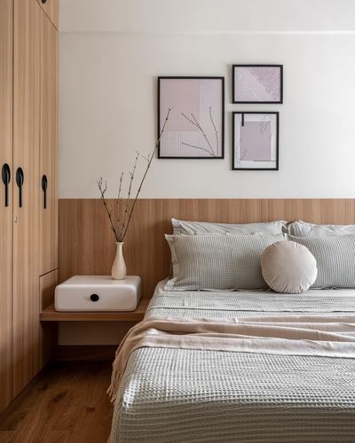 Japandi bedroom with wood-panelled lower wall, floating nightstand, and framed pink artwork above bed