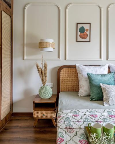 Bedroom corner with cane headboard, cane nightstand, pendant light and molded wall panels