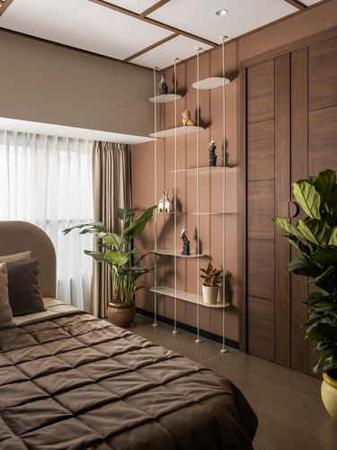 Bedroom corner with terracotta wall, suspended display shelves, wood wardrobe, and quilted bed