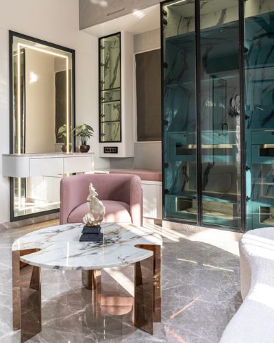 Living room corner with pink armchair, marble coffee table and teal glass wardrobe