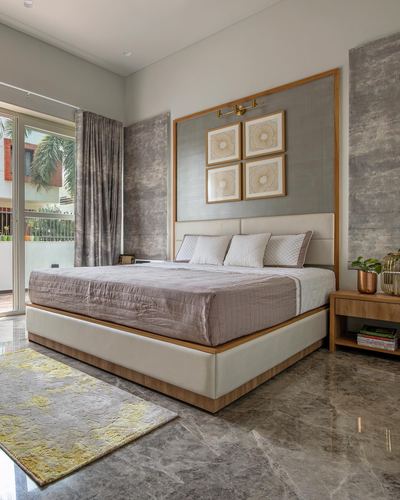 Contemporary bedroom with upholstered bed, marble flooring, textured grey wall panels and framed art