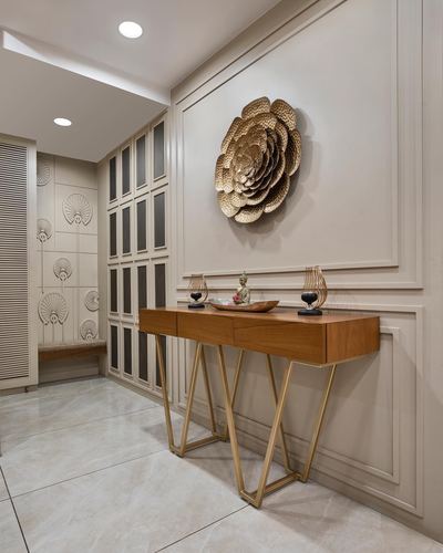 Entryway console with gold flower wall art on paneled beige wall