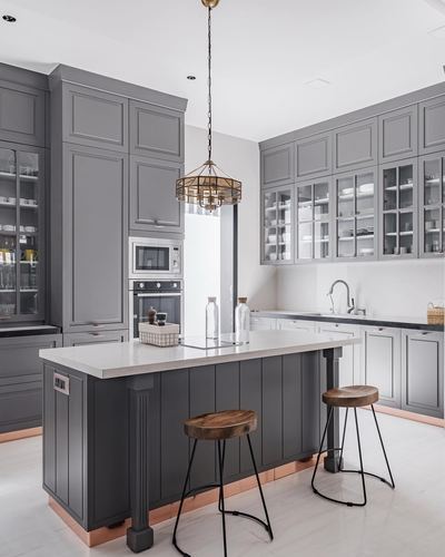 Grey shaker-style kitchen with island, glass cabinets, and a brass cage pendant light