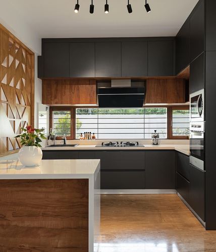 Modern black and wood kitchen with island, wood lattice wall, and horizontal window over hob