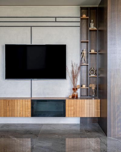 Living room with floating wood tv unit, grey textured wall, and vertical display shelf niche