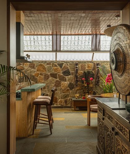 Kitchen bar with stone wall, carved wooden panels, glass block window and decorative gong disc