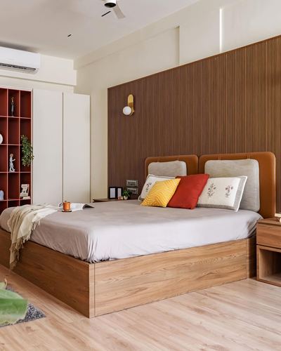 Bedroom with fluted wood headboard wall, tan leather headboard, and red-toned open shelving unit