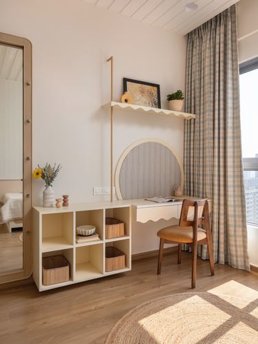Sunlit study nook with scalloped desk, round striped panel, cane chair and cubby storage with baskets