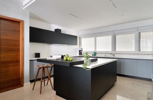 Modern black and white kitchen with island, bar stools, and large windows