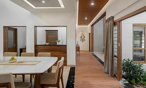 Dining area opening into a wood-floored hallway leading to a glazed courtyard door