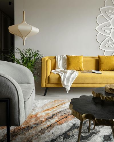 Living room with mustard velvet sofa, grey armchair, live-edge coffee table and floral wall art