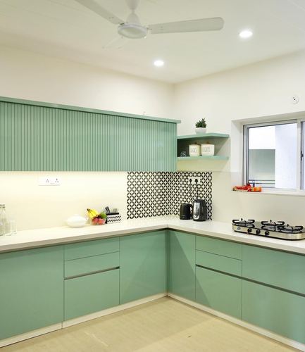 L-shaped modern kitchen with sage green cabinetry and patterned tile backsplash