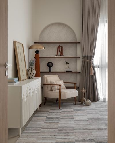 Corner reading nook with wood armchair beneath an arched shelved niche, seen through a doorway