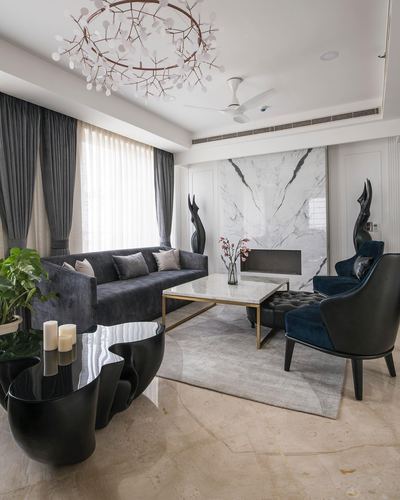 Living room with marble feature wall, navy velvet sofa, and sculptural black side table