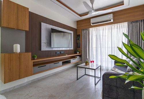 Living room with fluted wood wall, floating TV unit, grey sofa and marble-look coffee table