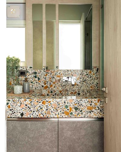 Terrazzo bathroom counter with segmented mirrors and wall-mounted faucet, Mumbai home