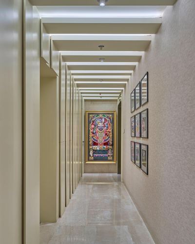 Long beige corridor with ribbed ceiling beams leading to a colorful framed painting