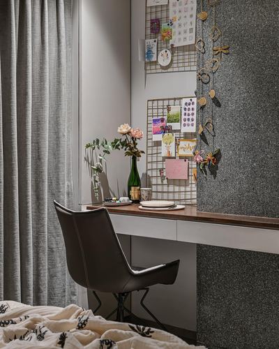 Study nook with leather chair, wooden desk, wire memo boards and textured grey stone wall