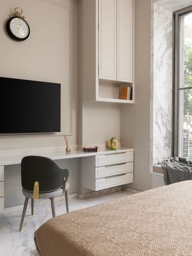 Beige bedroom with built-in desk, wall-mounted tv, and marble window seat