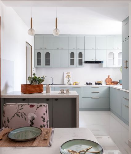 Powder blue U-shaped kitchen with island, arched cabinet glass and pendant lights