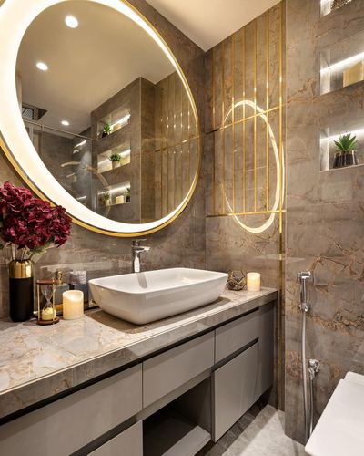 Bathroom vanity with round backlit mirror, stone countertop, and brass-fluted wall niches.