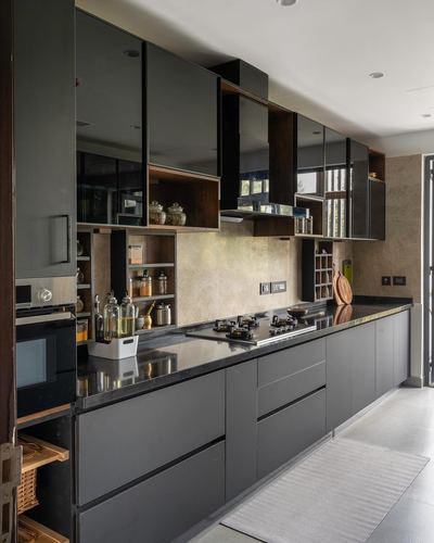 Dark grey galley kitchen with glossy cabinets, stone backsplash, black countertop and open wood shelving
