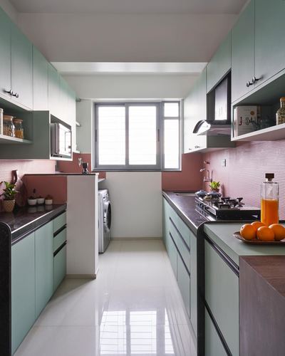 Mint green galley kitchen with pink textured backsplash and window at the end
