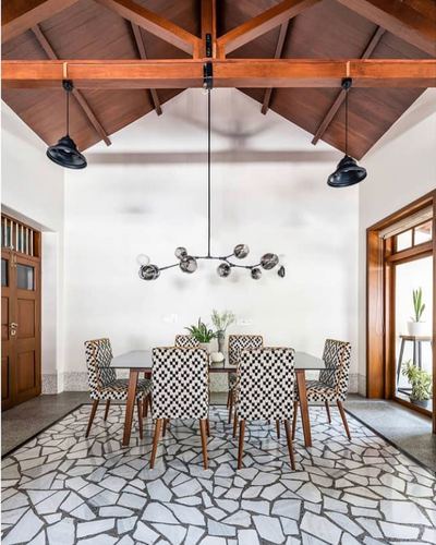 Dining room with exposed wood truss ceiling, sputnik chandelier, and patterned chairs over terrazzo floor