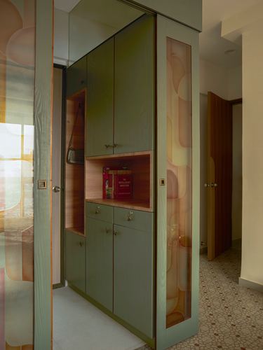 Foyer with olive-green wooden cabinetry, open wood-lined shelf niche, and frosted patterned glass door.