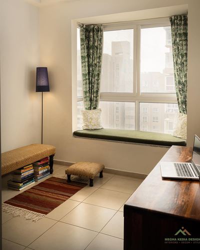 Bay window seat with green cushion, jute bench and desk with laptop in bright study nook