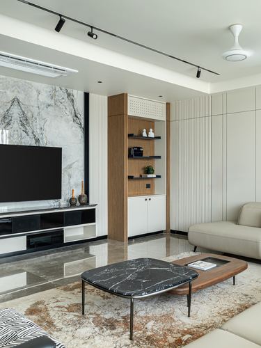Living room with marble feature wall, wood shelving niche, sofa and marble-top coffee table