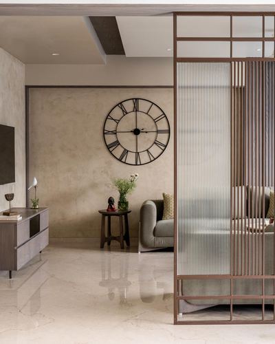 Living room with large roman numeral clock, textured plaster wall, and reeded glass wood partition