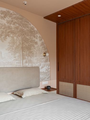 Bedroom with arched tree mural, grey upholstered headboard, and wood wardrobe wall