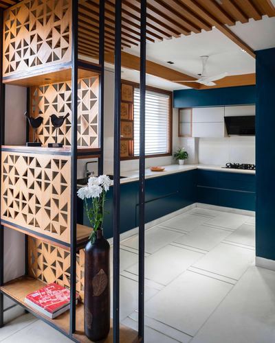 Wooden lattice room divider beside teal kitchen with slatted wood ceiling in New Delhi home