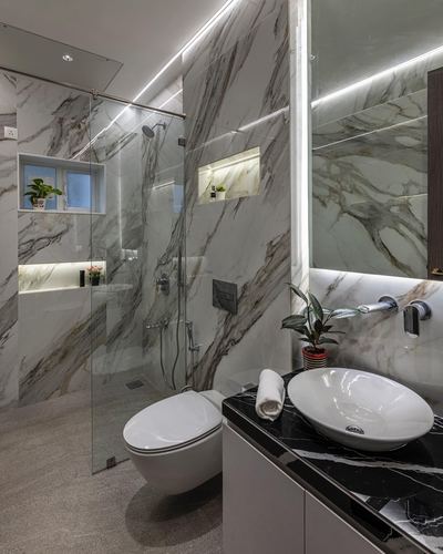Marble-clad bathroom with glass shower, wall-hung toilet, and black-marble vessel sink counter
